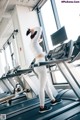 A woman is running on a treadmill in a gym.