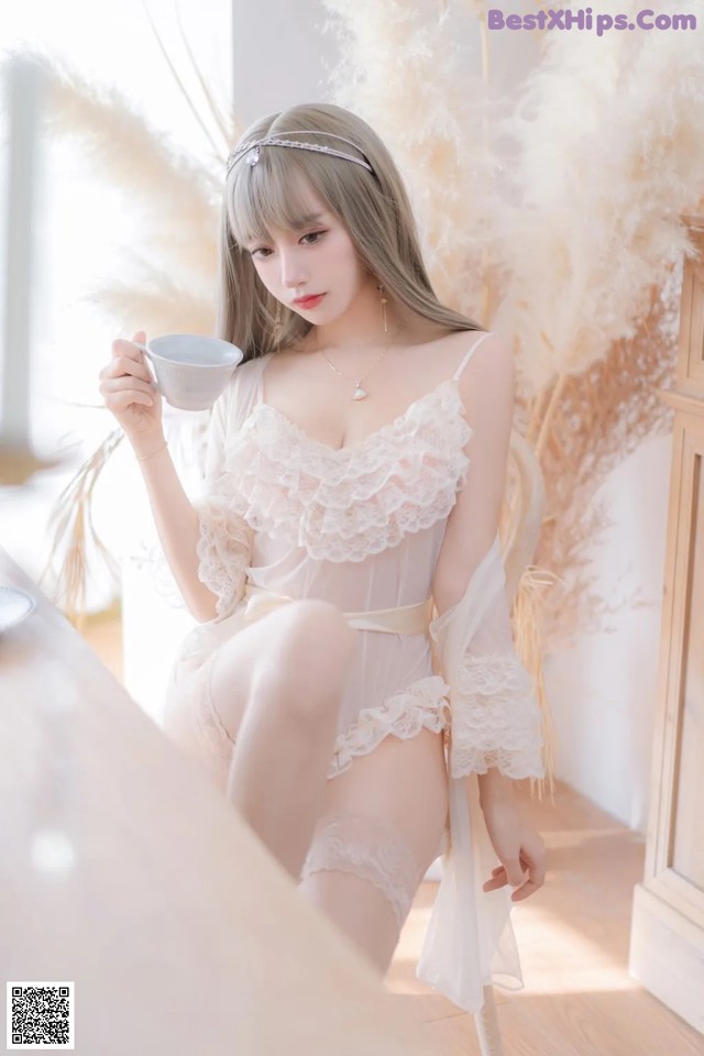 a woman sitting on a chair holding a cup of coffee