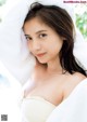 A woman wrapped in a white towel posing for a picture.