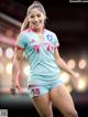 A woman in a blue and pink soccer uniform posing for a picture.