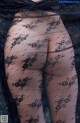 A close up of a woman's butt in black lace tights.