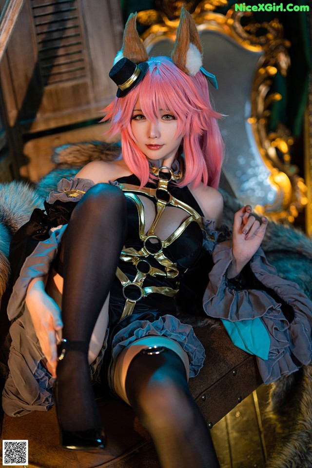 A woman with pink hair sitting on a chair.