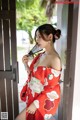 A woman in a red kimono holding a fan.